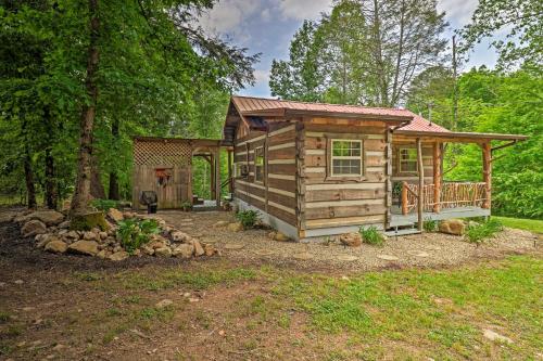 a log cabin in the woods with a porch at Covered Deck and Fire Pit Smoky Mountain Cabin in Cosby