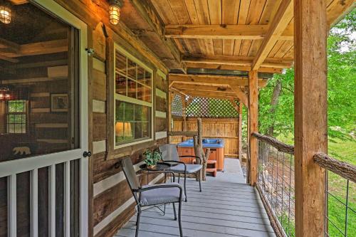 a wooden porch with chairs and a table on it at Covered Deck and Fire Pit Smoky Mountain Cabin in Cosby