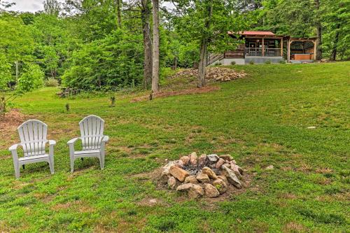 two chairs sitting next to a fire pit in a yard at Covered Deck and Fire Pit Smoky Mountain Cabin in Cosby