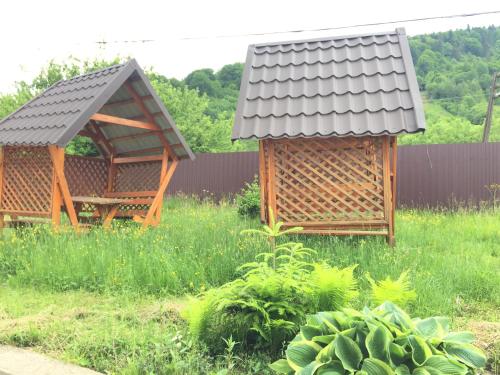 two gazebos in the middle of a garden at Карпатський Готель Олександрія in Mykulychyn