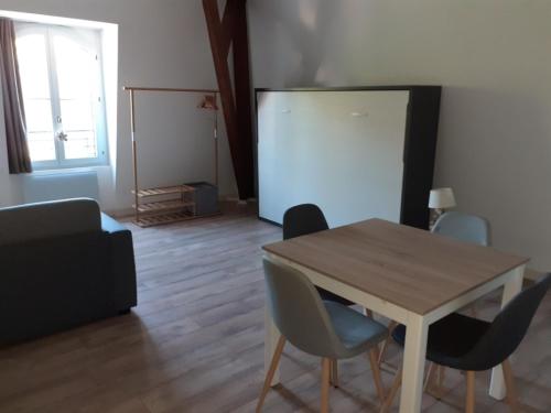 sala de estar con mesa de madera y sillas en Au coeur des remparts, residence du château*, en Gravelines