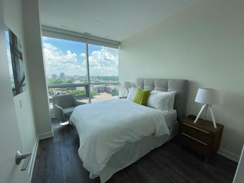 une chambre avec un grand lit et une grande fenêtre dans l'établissement LIV Extended Stay, à Ottawa