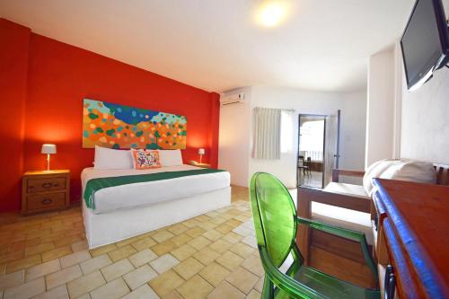 a bedroom with a bed with an orange wall at Emperador Vallarta Beachfront Hotel and Suites in Puerto Vallarta
