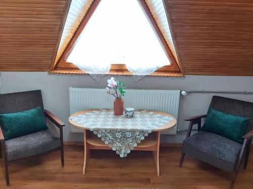 1 mesa y 2 sillas en una habitación con ventana en Luna Apartman en Gyula