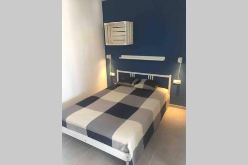 1 dormitorio con 1 cama con pared azul en Sea View Loft, en Playa Blanca