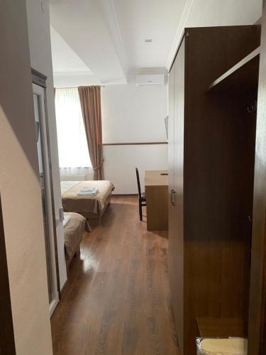 a small room with two beds and a window at Grand Hotel in Mohyliv-Podilʼsʼkyy