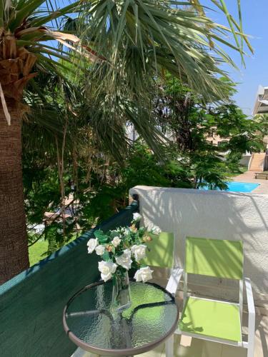 a glass table with a vase of flowers on a chair at Theodoros Apt. 408 in Protaras