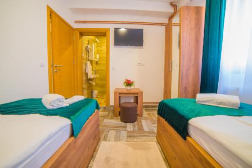 a room with two beds and a table with a television at Užički konak in Užice