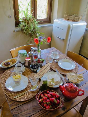 a table with plates of food and a refrigerator at B&B Sant'Anna 21 in Monforte dʼAlba