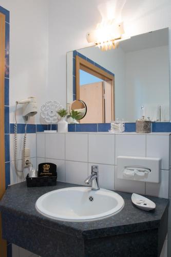 a bathroom with a sink and a mirror at Saar Galerie in Saarburg