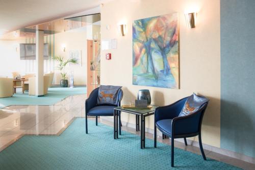 a waiting room with two chairs and a table and a painting at Saar Galerie in Saarburg