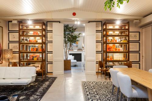 a dining room with a table and chairs and bookshelves at Hotel Margot House Barcelona in Barcelona