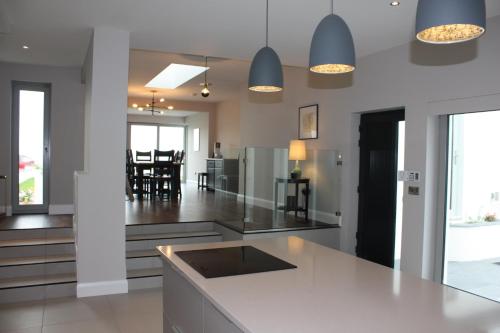 a kitchen with a white counter and a dining room at Sea Vista - Rathmullan in Rathmullan