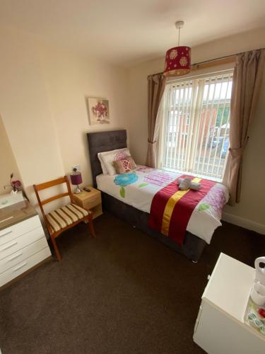 a bedroom with a bed and a window and a chair at The Homestar in Skegness