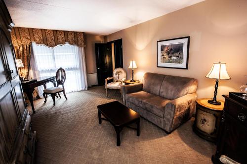 a living room with a couch and a chair at Old Stone Inn Boutique Hotel in Niagara Falls