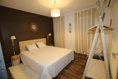 - une chambre avec un lit blanc et un tripod dans l'établissement Appartement et Garage au Cœur de l'Isle, à LʼIsle-sur-la-Sorgue