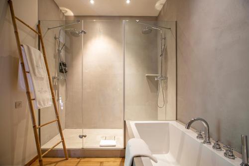 a bathroom with a shower and a white tub at Hotel Margot House Barcelona in Barcelona