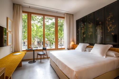 a bedroom with a large bed and a large window at Hotel Margot House Barcelona in Barcelona