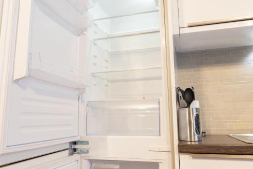 a refrigerator with its door open in a kitchen at Executive City Centre Apartment with Gated Parking and Stylish Rooms includes Privacy and Space with Luxury Feel plus Courtyard Garden in Amazing Location and Very Highly Rated in Peterborough