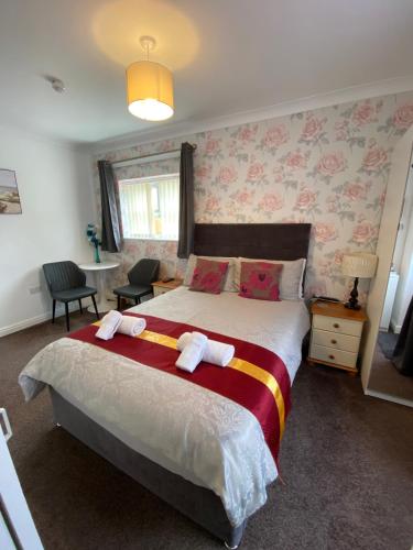 a bedroom with a large bed with pink floral wallpaper at The Homestar in Skegness