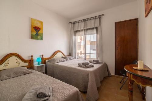 a bedroom with two beds and a window at Armação Beach Residences in Armação de Pêra