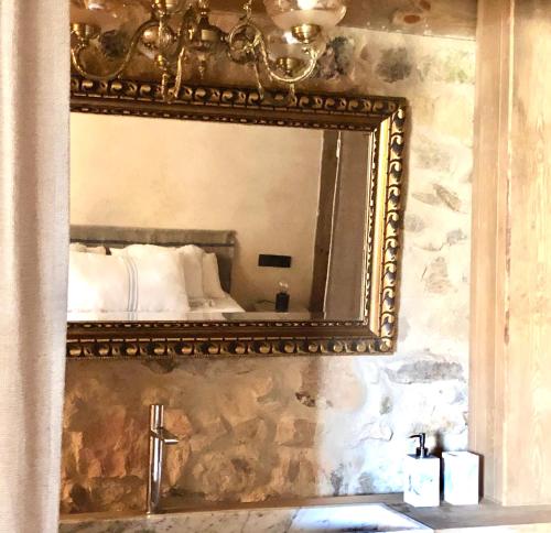 a mirror on a wall above a bathroom sink at El pajar de abajo - Pedraza - in La Alameda