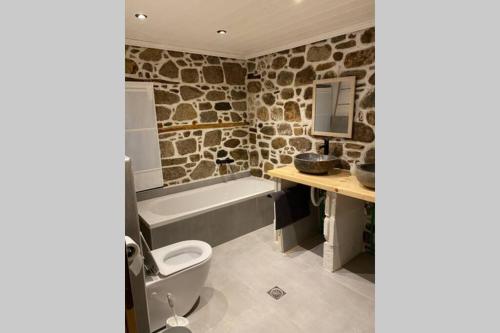 uma casa de banho com um WC, um lavatório e uma banheira em Sfeervol gerenoveerd huis in oud Grieks dorp em Sikia