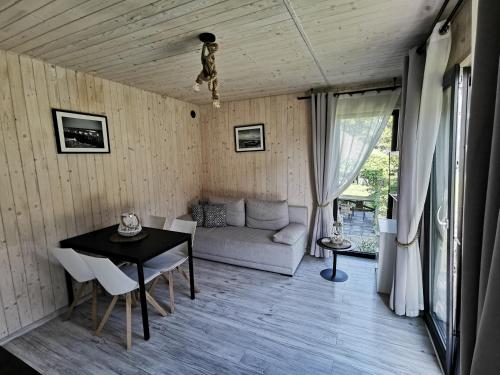 uma sala de estar com uma mesa e um sofá em Domek Morski em Swarzewo