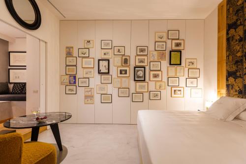 a bedroom with a bed and a wall of pictures at Hotel Margot House Barcelona in Barcelona