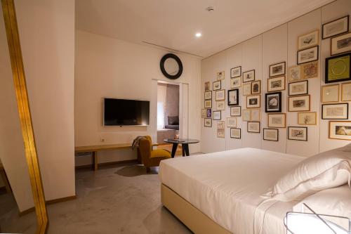 a bedroom with a bed and a desk and a tv at Hotel Margot House Barcelona in Barcelona