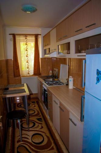 a small kitchen with a refrigerator and a table in it at Apartament 2 camere in Haţeg