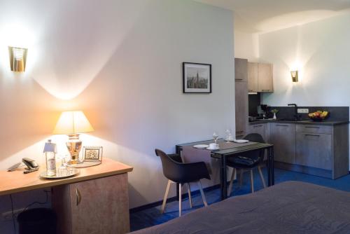 a room with a bed and a kitchen with a table and chairs at Saar Galerie in Saarburg