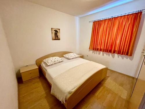 een kleine slaapkamer met een bed en een raam bij Apartments Šime in Šibenik