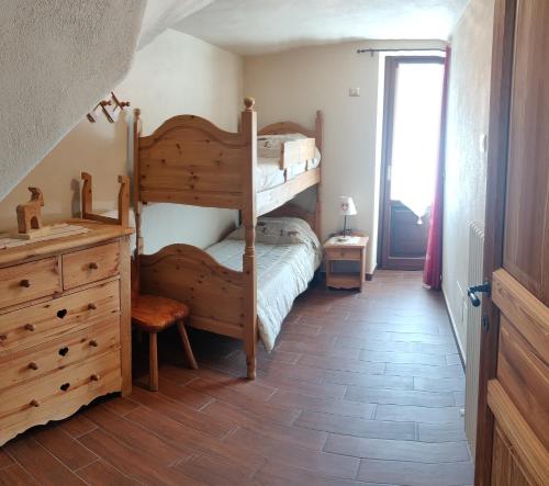 a bedroom with two bunk beds and a wooden floor at CASA VACANZE CLO 3 CAMERE 2 BAGNI in Aosta