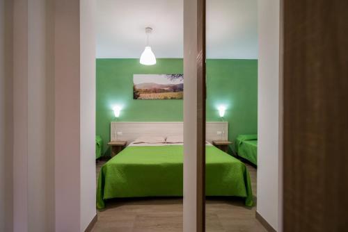 a bedroom with green walls and a green bed at La Duchessa e Il Contadino in Vieste