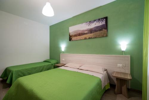 a bedroom with two beds with green walls at La Duchessa e Il Contadino in Vieste