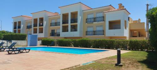 a building with a swimming pool in front of it at Apartamento piscina 5 minutos praia in Alcantarilha