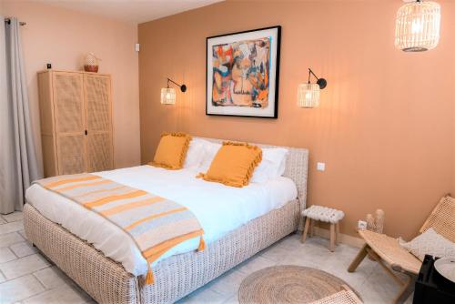 ein Schlafzimmer mit einem Bett mit orangefarbenen Kissen darauf in der Unterkunft La Parenthèse de Marie in Tourrettes-sur-Loup