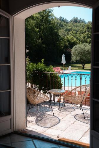 un patio avec une table et des chaises et une piscine dans l'établissement La Parenthèse de Marie, à Tourrettes-sur-Loup
