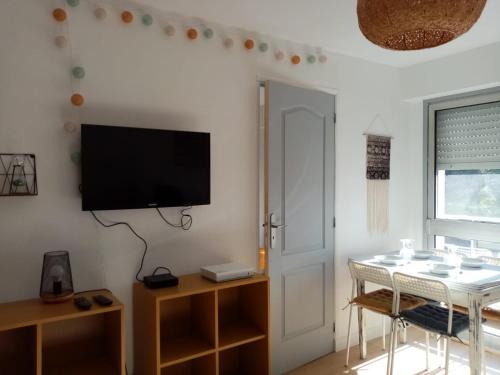 ein Wohnzimmer mit einem Flachbild-TV an der Wand in der Unterkunft Appartement cocoon à Courseulles sur Mer in Courseulles-sur-Mer