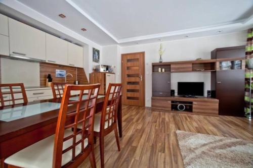a kitchen and dining room with a table and chairs at Apartament Oliwkowy in Szklarska Poręba