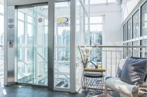 a balcony with glass doors and a chair at Saar Galerie in Saarburg