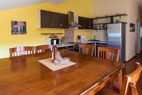 a kitchen with a wooden table with wine glasses on it at Apartments Villa Americana in Jadranovo