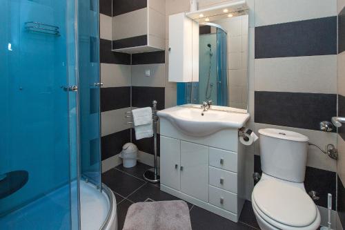 łazienka z toaletą i umywalką w obiekcie Apartments Villa Americana w mieście Jadranovo
