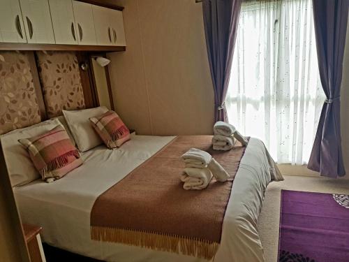 a bedroom with a bed with towels on it at No42 Wild Goose in Dornoch