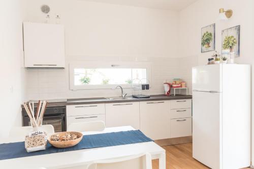a kitchen with white cabinets and a white refrigerator at Appartamento nuovo da Lilly con terrazza tra centro e mare in Fano