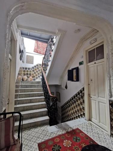 a staircase in a house with a door and a rug at Bayt Alice Hostel in Tangier