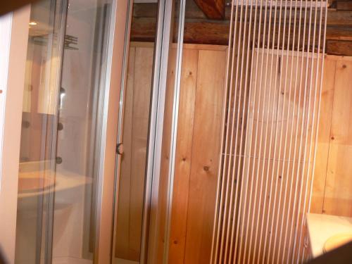 - une cabine de douche en verre avec des placards en bois dans l'établissement STARA PLEBANIA, à Lądek-Zdrój