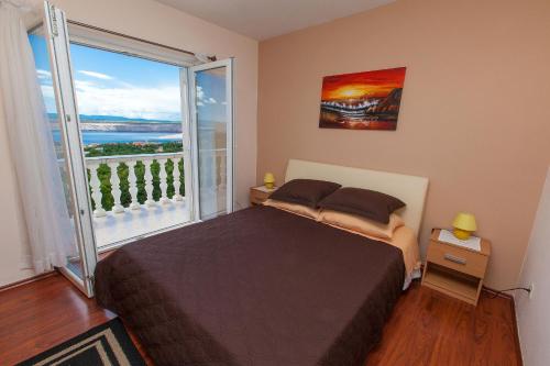 um quarto com uma cama e uma grande janela em Apartments Villa Americana em Jadranovo