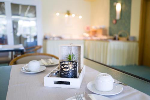 a table with two plates and a candle on it at Saar Galerie in Saarburg